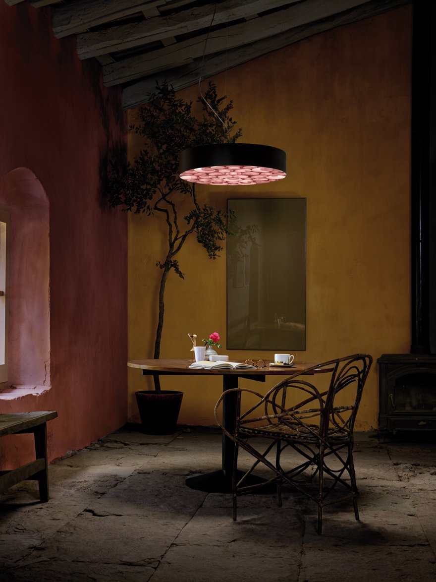 Reading area-with-circular-suspension-lamp-with-black-frame-and-interior-of-irregular-spirals-of-wood-veneer-in-pink-color